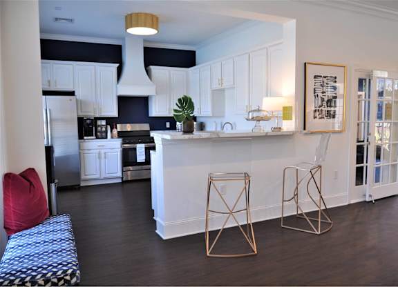 A kitchen with white cabinets and a black and white checkered bench.
