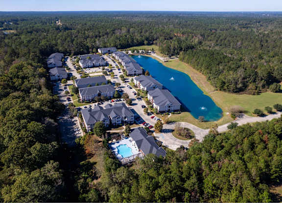 A bird's eye view of a resort with a swimming pool and a lake.