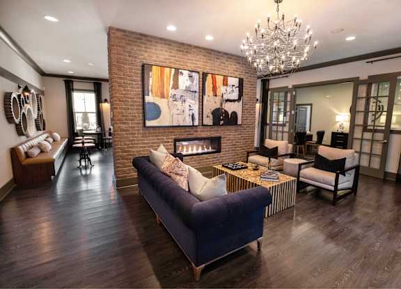 A living room with a blue couch and a chandelier.