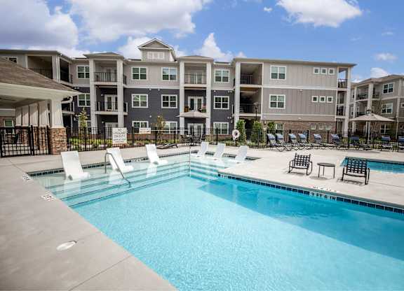 A swimming pool in front of apartment buildings.