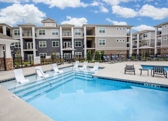 A swimming pool in front of apartment buildings.