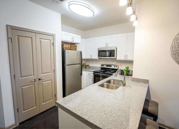 A kitchen with a sink, stove, and refrigerator.