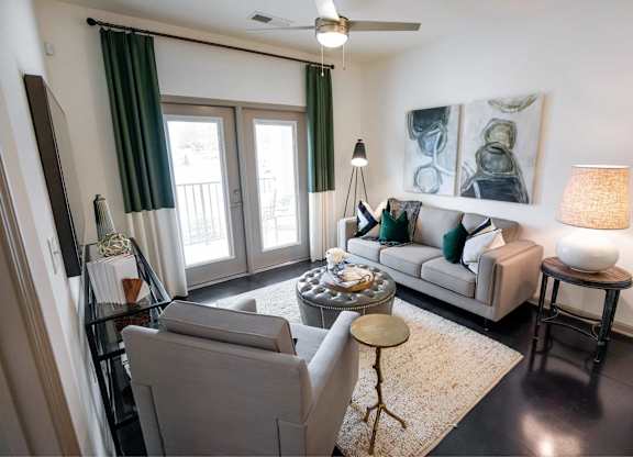 A living room with a grey couch, a coffee table, and a painting on the wall.