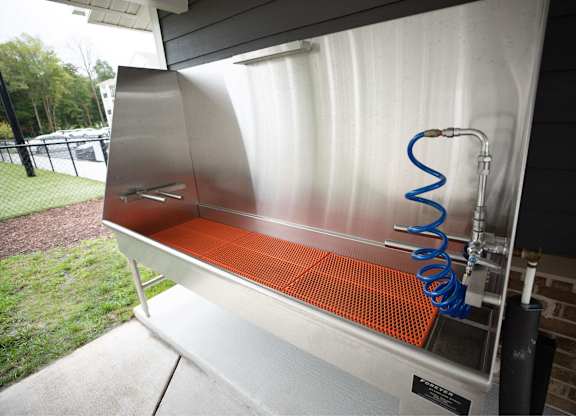 A stainless steel grill with a blue spring on top.