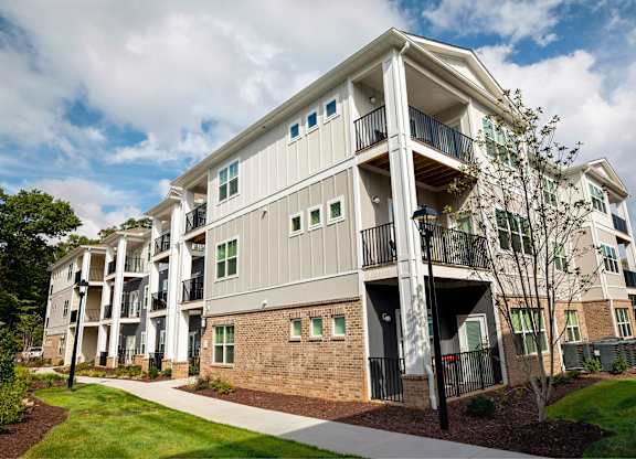 A modern apartment building with balconies and a brick facade.