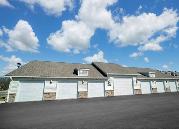 A large building with a grey roof and white garage doors.