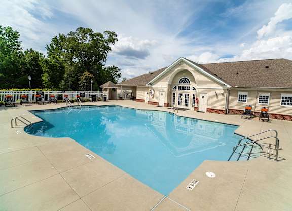 A large outdoor swimming pool with a building in the background.