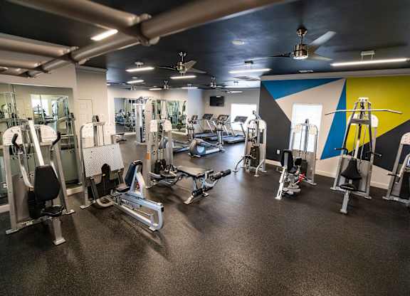 A gym with a variety of equipment including weights and machines.
