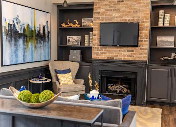 A living room with a fireplace and a painting on the wall.