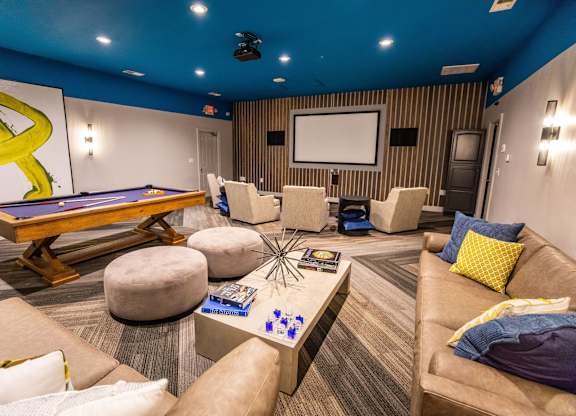 A room with a pool table and a couch.