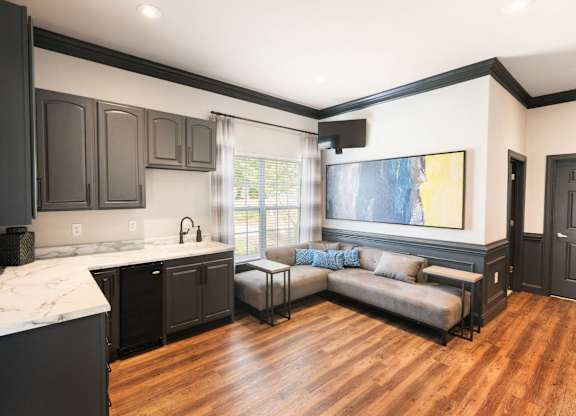 A kitchen with black cabinets and a marble countertop.