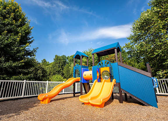 A playground with a blue and orange slide.