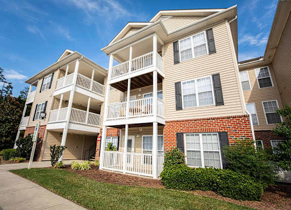 A two-story apartment building with a balcony on the second floor.