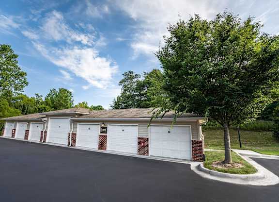 A row of garage doors are on the side of a building.
