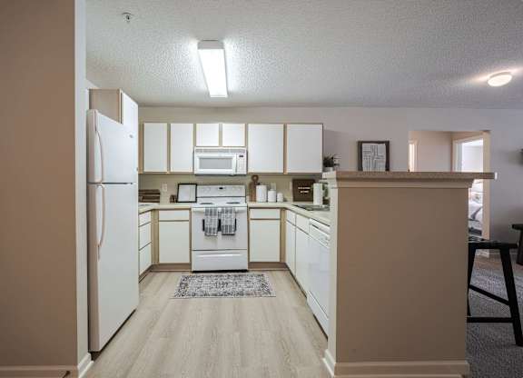 A kitchen with white appliances and cabinets.