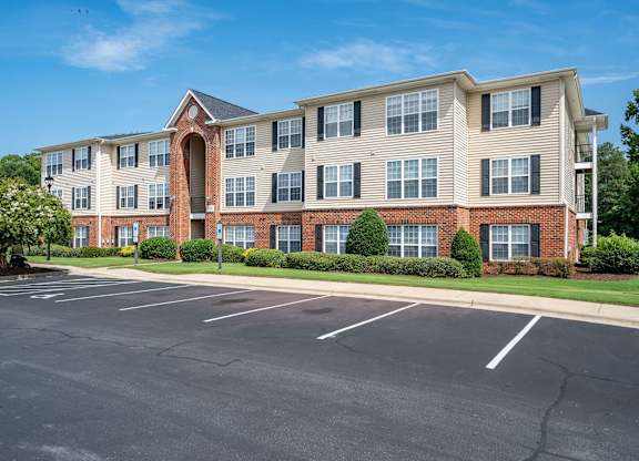 A large brick building with a parking lot in front.