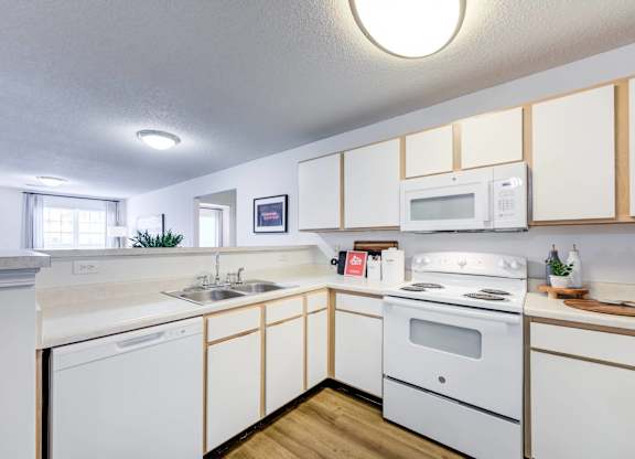 A white kitchen with wooden cabinets and a white stove.