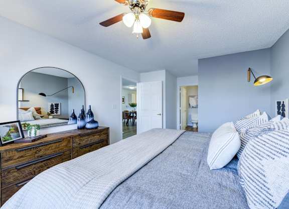 A bedroom with a large bed and a ceiling fan.