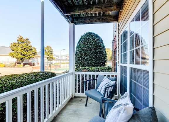 A small balcony with a bench and pillows.