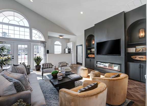 A modern living room with a grey sofa, a black coffee table, and a large window.