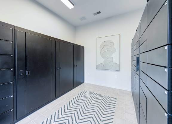 A hallway with black doors and a white and black chevron patterned floor.