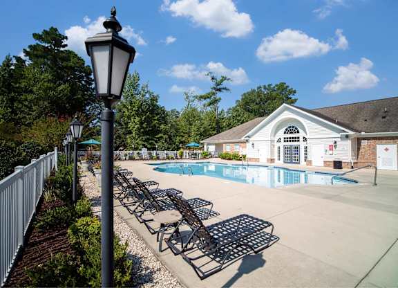 A pool area with sun loungers and a lamp post.