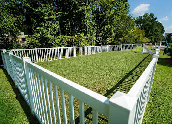 A white fence encloses a green lawn.