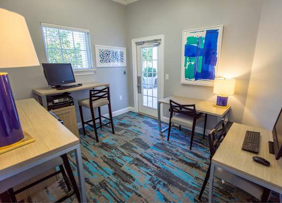 A room with a blue carpet and a painting on the wall.