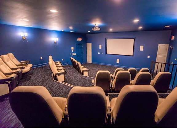 A movie theater with rows of seats facing a screen.