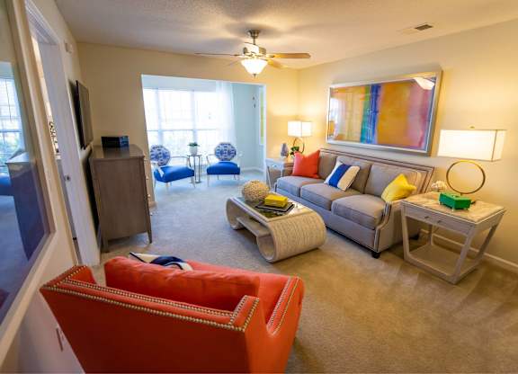 A living room with a red couch and a grey couch.