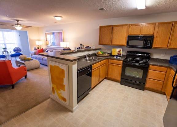 A kitchen with black appliances and wooden cabinets.