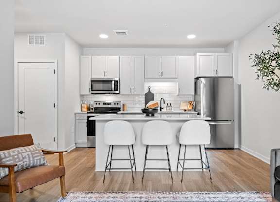 A kitchen with white cabinets and a refrigerator.