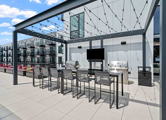 A patio with a table and chairs under a white awning.