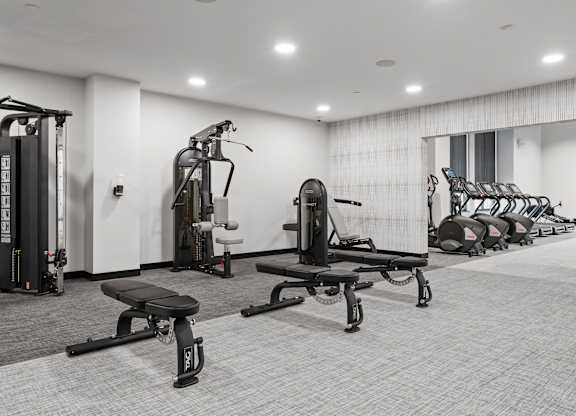 A black and white photo of a gym with a variety of equipment.