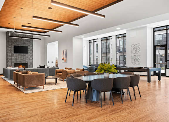 A modern living room with a fireplace and a dining table set up.