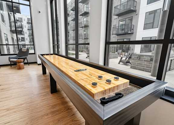 A shiny wooden table with black and yellow game pieces on it.