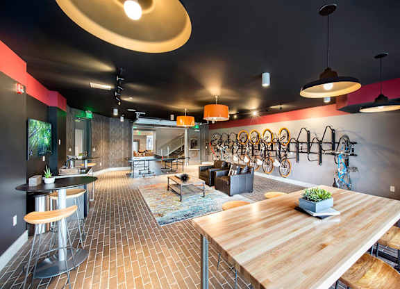 A modern room with a long wooden table and bicycle rack on the wall.