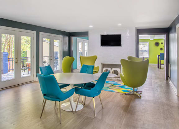A modern dining room with a white table and blue chairs.