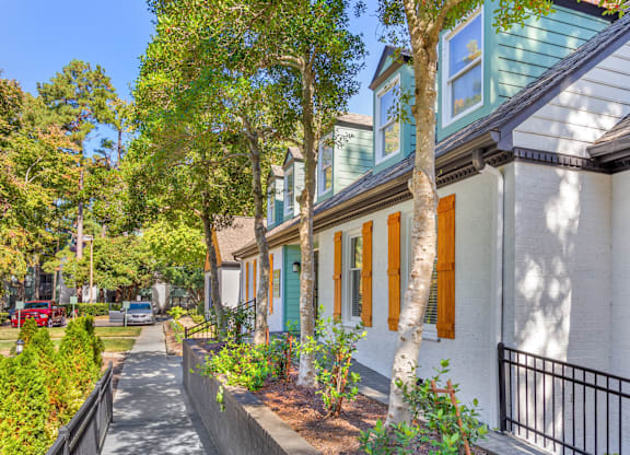 A row of houses with green shutters and white walls.