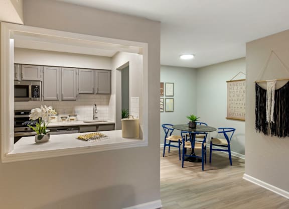 A kitchen with a dining table and chairs.