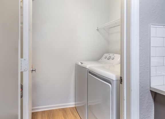 A small white fridge in a narrow room.