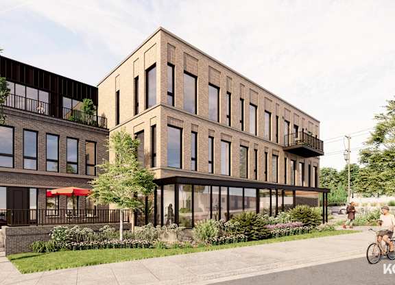 A modern building with a balcony and a bicycle parked in front.