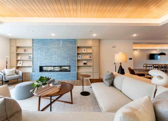 A modern living room with a fireplace and a wooden ceiling.