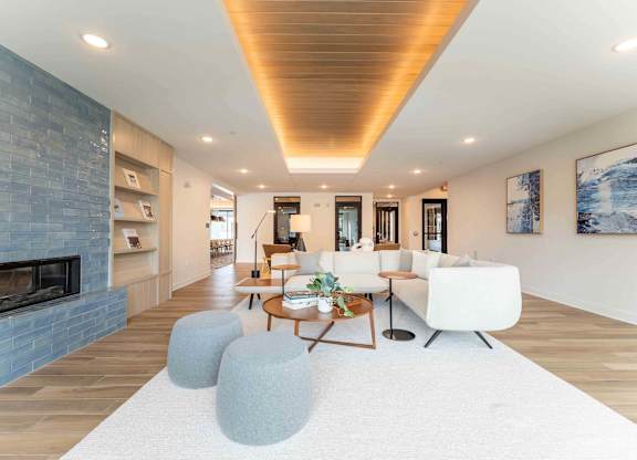 A modern living room with a fireplace and a white rug.