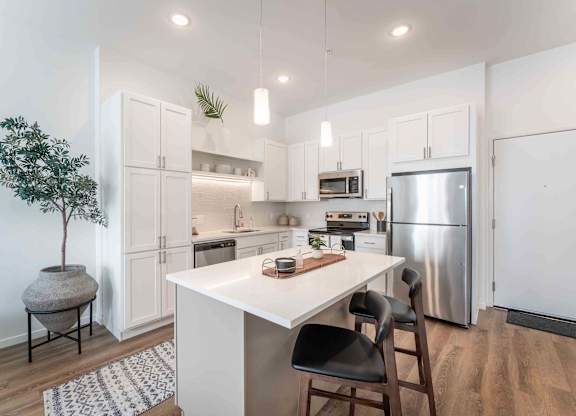 A kitchen with a white table and black chairs.