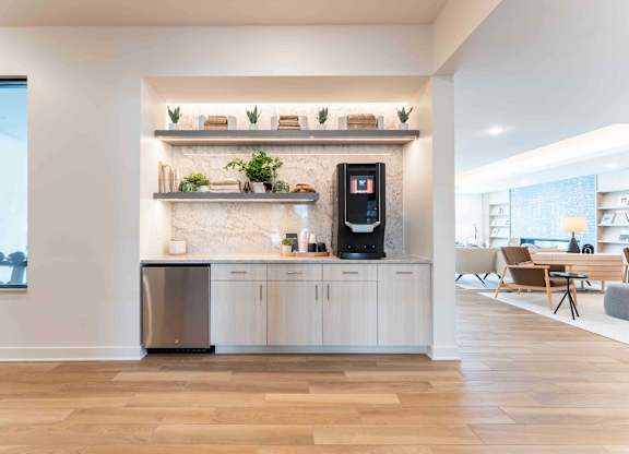 A modern kitchen with a refrigerator, oven, and a counter with a plant on it.