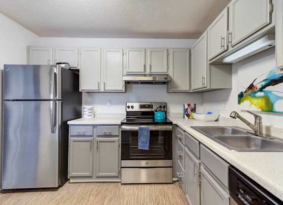 A kitchen with a stainless steel refrigerator and a stainless steel oven.