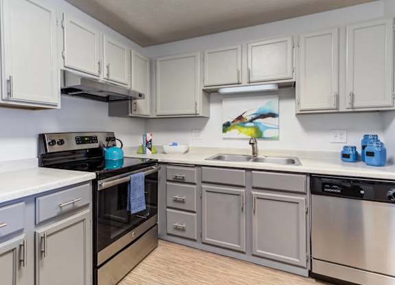 A kitchen with white cabinets and stainless steel appliances.