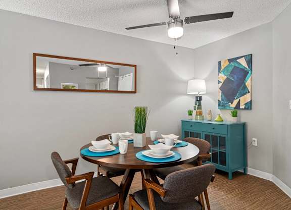 A dining room with a round table set for two.