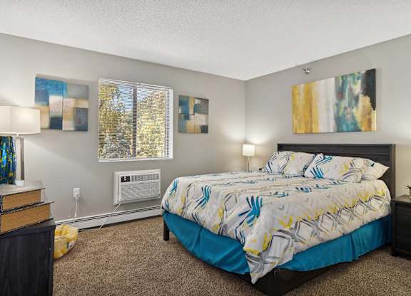 A bedroom with a bed, nightstand, and two wall art pieces.